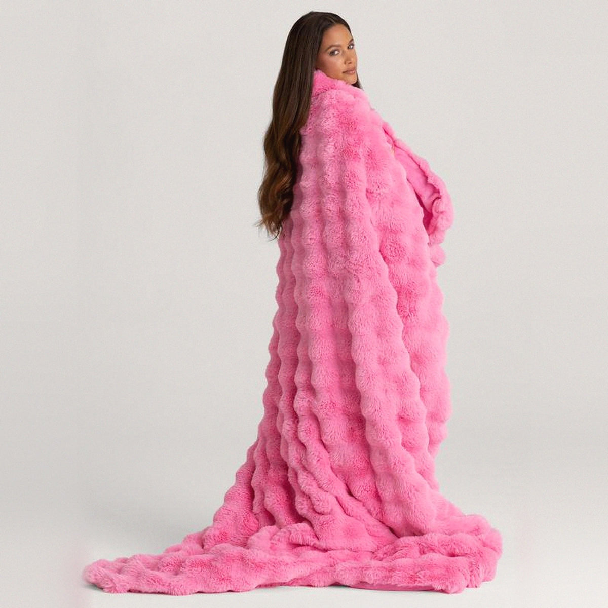 Mochi Mellow Cloud Heated Lavender Throw in Pink — Pink heated lavender throw draped over a woman's shoulders, pooling on the floor