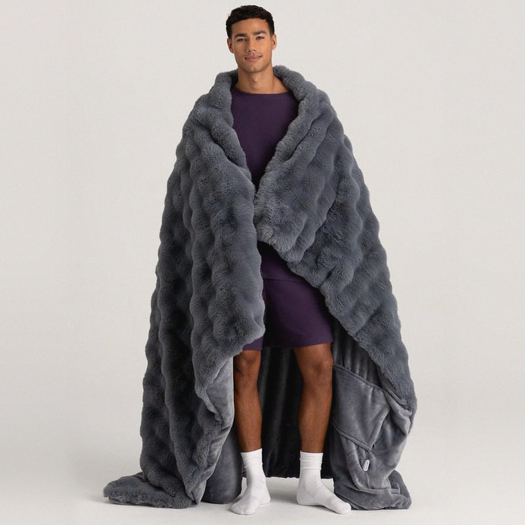 Mochi Mellow Cloud Heated Lavender Throw in Slate — Slate grey heated lavender throw wrapped around a man, showing the plush fur outside and the smooth fleece inside