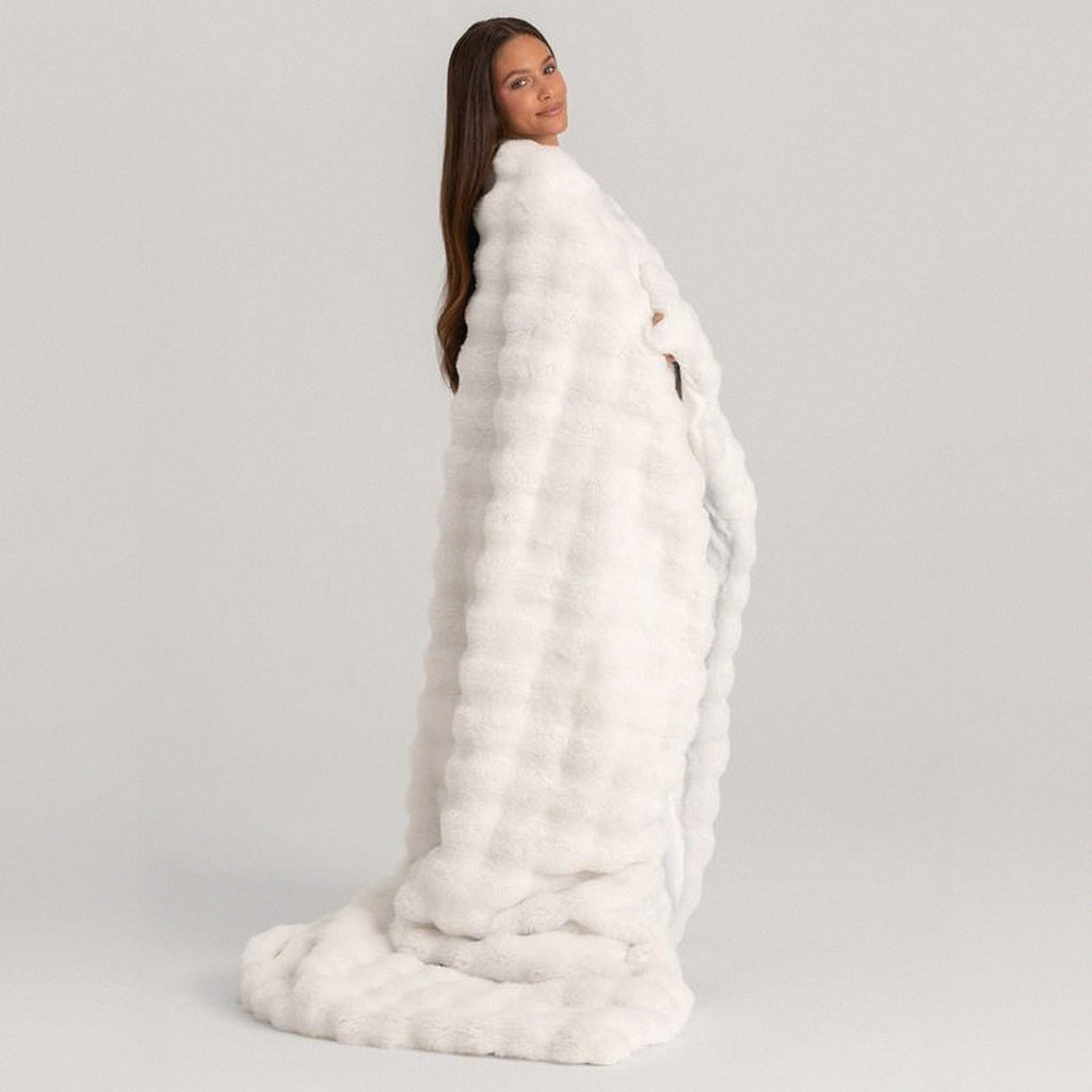 Mochi Mellow Cloud Heated Lavender Throw in White — White heated lavender throw draped over a woman's shoulders