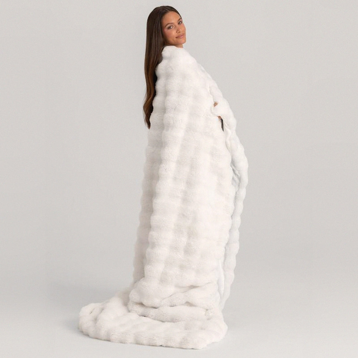 Mochi Mellow Cloud Heated Lavender Throw in White — White heated lavender throw draped over a woman's shoulders