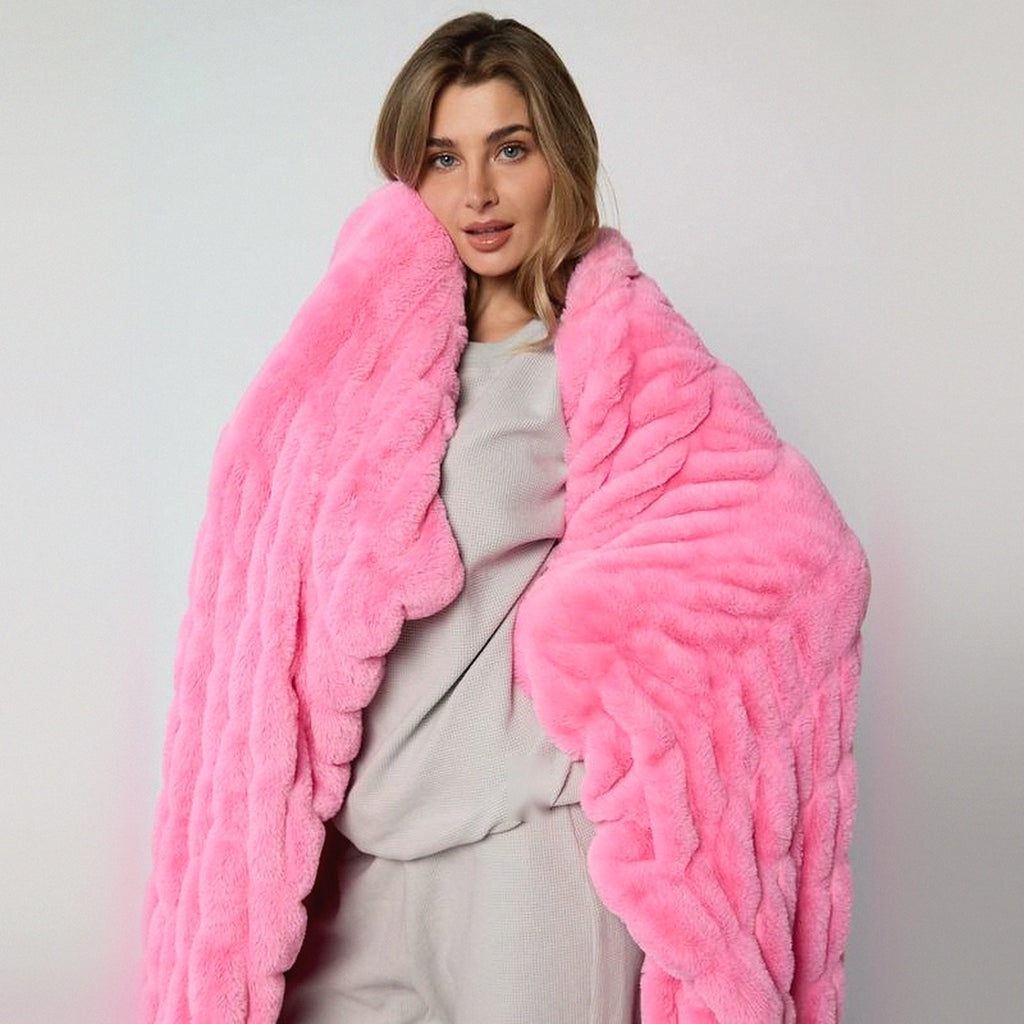 Mochi Mellow Cloud Throw in Bubblegum — Bubblegum pink ruched faux-fur throw held up around a woman's shoulders
