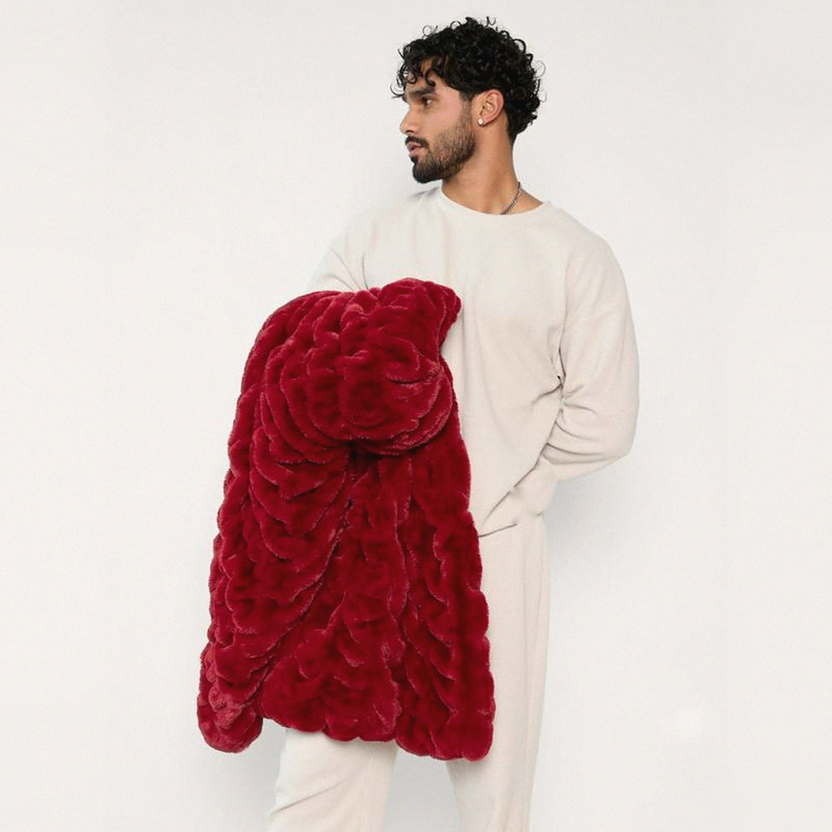 Mochi Mellow Cloud Throw in Burgundy — Burgundy ruched faux-fur throw folded over a man's arm