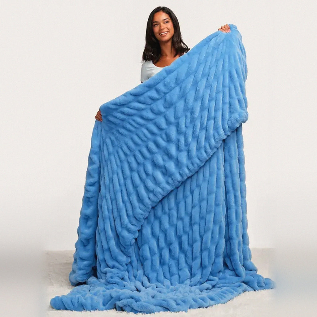 Mochi Mellow Cloud Throw in Cornflower — Woman holding up the cornflower blue ruched faux-fur throw to show its full size